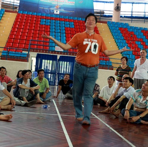 Ông Dư Quang Châu, thầy giáo môn cảm xạ hướng dẫn lại cách đi trên than hồng cho học trò nắm vững.